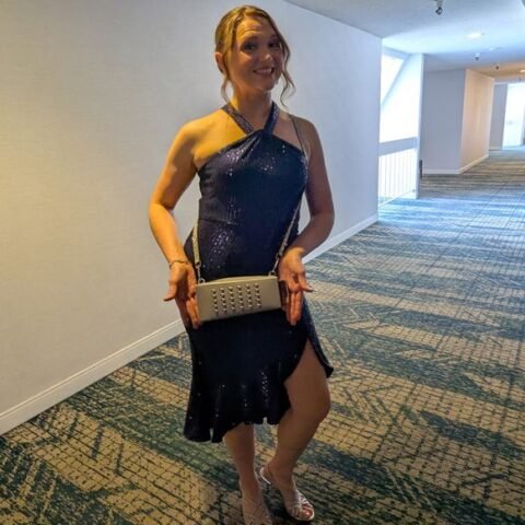 Fan in a navy sequin dress holding the silver Grater Purse clutch