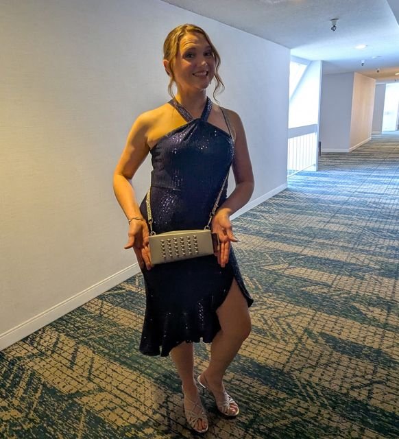 Fan in a navy sequin dress holding the silver Grater Purse clutch
