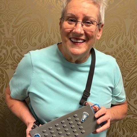 Fan smiling with a gray Grater Purse decorated with Detroit Lions charms