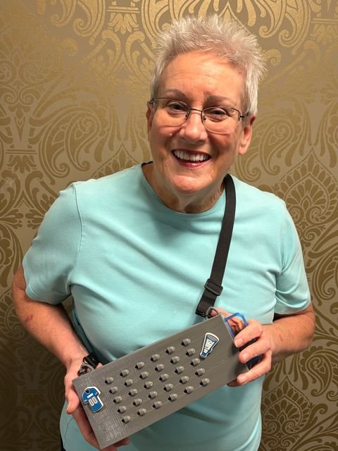 Fan smiling with a gray Grater Purse decorated with Detroit Lions charms