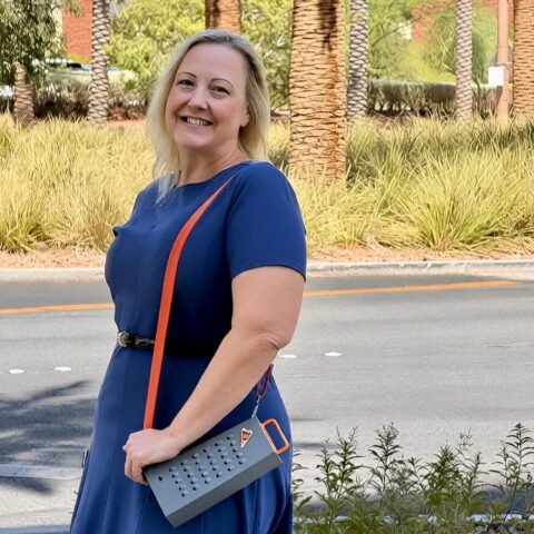 female fan wearing grater purse palm trees